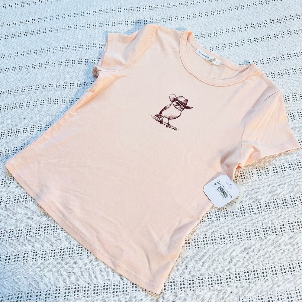 Light peachy bird with cowboy hat graphic tee